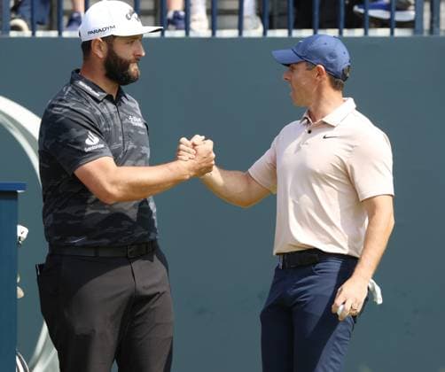 Northern Ireland s Rory Mcllroy shakes Spain s Jon Rahm s hand on the 1st tee on the first day at the 151st Open Championship at Royal Liverpool Golf Club in Hoylake, England on Thursday, July 20, 2023.  LON2023072083f HUGOxPHILPOTT