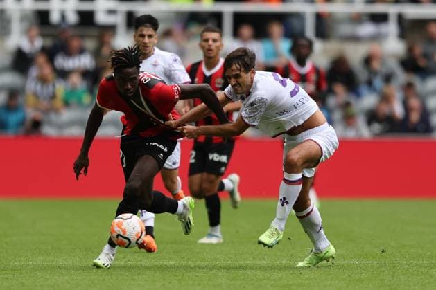 NEWCASTLE UPON TYNE, ENGLAND AUGUST 06: Luca Ranieri (R) of ACF Fiorentina tries to hold off Ewann Guessand (L) of OGC Nice during the Sela Cup soccer match between ACF Fiorentina and OGC Nice at St. James Park on August 06, 2023 in Newcastle upon Tyne, England. Sela Cup soccer tournament SELA_2023
