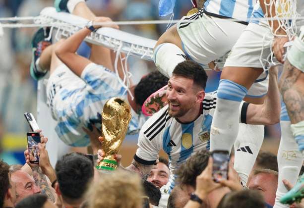 Lionel MESSI, Argentina 10 lifted on shoulders with WC trophy while Lautaro MARTINEZ, Argentina 22 Rodrigo De Paul of Argentina ad Leandro PAREDES, Argentina 5 Paulo DYBALA, Argentina 21 sit on the goal in the WC Final match ARGENTINA - FRANCE 3-3 (7-5 after penalty shoot out) FIFA World Cup, WM, Weltmeisterschaft, Fussball 2022 QATAR Season 2022 2023, Dec 18, 2022 in Lusail Stadium in Doha, Qatar.