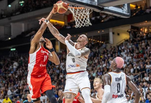 Basketball: Laenderspiele, Deutschland - Kanada, Mercedes-Benz Arena. Kyle Alexander (l) aus Kanada springt zum Korb gegen Deutschlands Daniel Theis (M). Basketball: Laenderspiel Deutschland - Kanada
