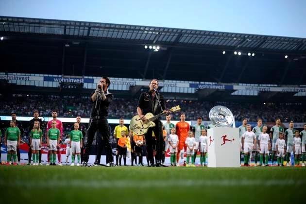 18.08.2023, Fussball 1. Bundesliga 2023 2024, 1. Spieltag, SV Werder Bremen - FC Bayern München, im Wohninvest Weserstadion Bremen. Sänger von Boss Hoss performen die Deutsche Nationalhymne vor dem Spiel auf dem Platz, Alec Völkel, Gesang, Rhythmusgitarre, Sascha Vollmer