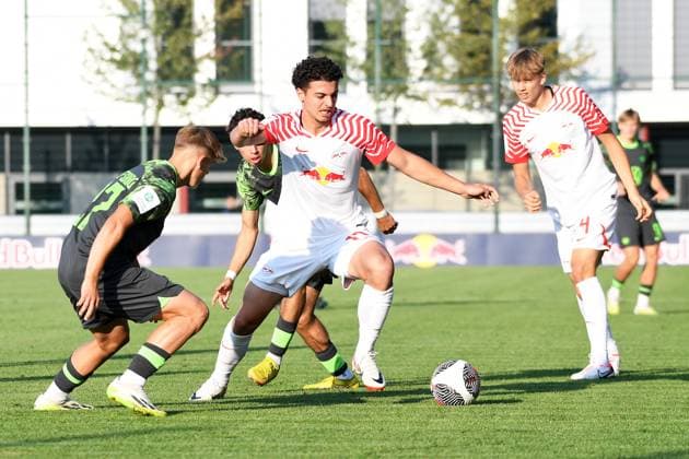 Fußball A-Junioren-Bundesliga Nord Nordost, Saison 2023 2024, 3. Spieltag, RasenBallsport Leipzig U19 vs. VfL Wolfsburg U19 (23.08.2023) Zweikampf um den Ball zwischen Aris Bayindir (Zentrales Mittelfeld RB Leipzig U19, Rueckennummer 17) (Mitte) und Kevin Lebersorger (Rechter Verteidiger Wolfsburg U19, Rueckennummer 27) (li.) und Jonathan Vonheim Norbye (Innenverteidiger RB Leipzig U19, Rueckennummer 4) (re.) beim Spiel RBL U19 gegen Wolfsburg U19 (23.08.2023) Leipzig Sachsen Deutschland RB-Trainingszentrum am Cottaweg, Rasenplatz 1