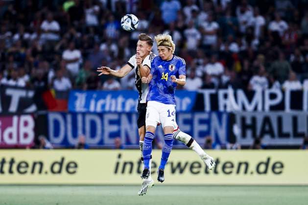 Wolfsburg, Volkswagen-Arena, 09.09.23: Nico Schlotterbeck of germany (L)jumps for a header against Junya Ito of japan during the friendly match between Germany vs. Japan.