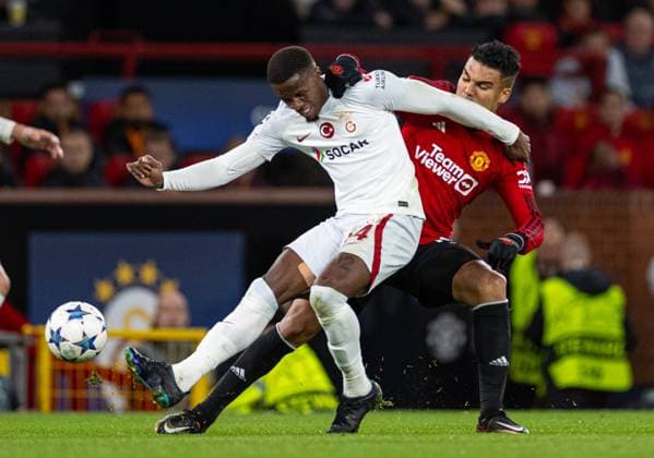 Football - UEFA Champions League - Group A - Manchester United, ManU FC v Galatasaray S.K. MANCHESTER, ENGLAND - Tuesday, October 3, 2023: Galatasaray s Wilfried Zaha (L) is challenged by Manchester United s Carlos Henrique Casimiro during the UEFA Champions League Group A match between Manchester United FC and Galatasaray S.K. at Old Trafford. MANCHESTER Old Trafford GREATER MANCHESTER ENGLAND  Copyright: xDavidxRawcliffex P2023-10-03-Man_Utd_Galatasaray-34