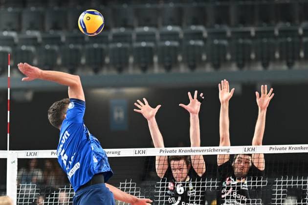 Volleyball I Herren I 2023-2024 I Bundesliga I DVV Pokal Achtelfinale I SVG Lüneburg - Baden Volleys SSC Karlsruhe I 4.11.2023 Erik Johannes Röhrs (5, SVG Lüneburg) überschlägt den Block von Felix Roos (6, BADEN VOLLEYS SSC Karlsruhe) und Jannik Brentel (3, BADEN VOLLEYS SSC Karlsruhe) Lüneburg LKH Arena Niedersachsen Deutschland Copyright: xLobeca AndreasxHannigx