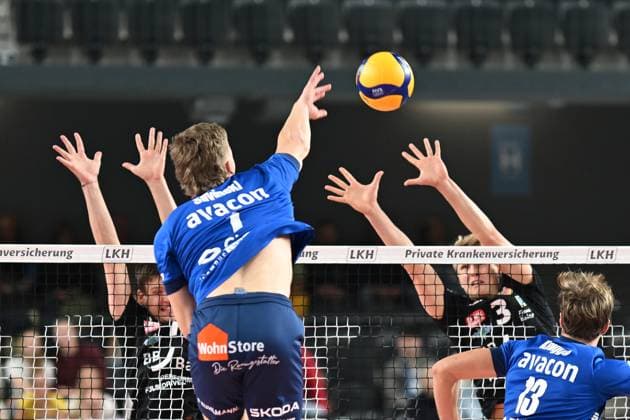Volleyball I Herren I 2023-2024 I Bundesliga I DVV Pokal Achtelfinale I SVG Lüneburg - Baden Volleys SSC Karlsruhe I 4.11.2023 Matthew Augus Slivinski (1, SVG Lüneburg) überschlägt den Block von Benjamin Dollhofer (10, BADEN VOLLEYS SSC Karlsruhe) und Jannik Brentel (3, BADEN VOLLEYS SSC Karlsruhe) Lüneburg LKH Arena Niedersachsen Deutschland Copyright: xLobeca AndreasxHannigx