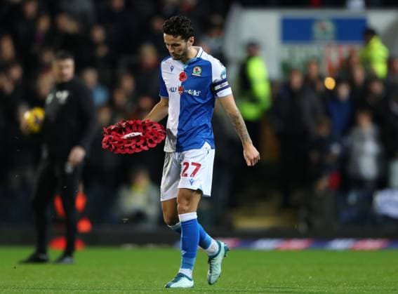 10th November 2023; Ewood Park, Blackburn, England; EFL Championship Football, Blackburn Rovers versus Preston North End; Lewis Travis of Blackburn Rovers lays a Poppy wreath during the Remembrance Day commemorations  ActionPlus12574747 DavidxBlunsden