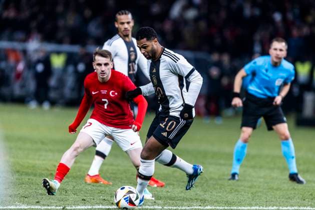 Berlin, Olympiastadion, 18.11.23: Kerem Aktuerkoglu of turkey challenges Serge Gnabry of germany during the friendly match between Germany vs. Turkey.