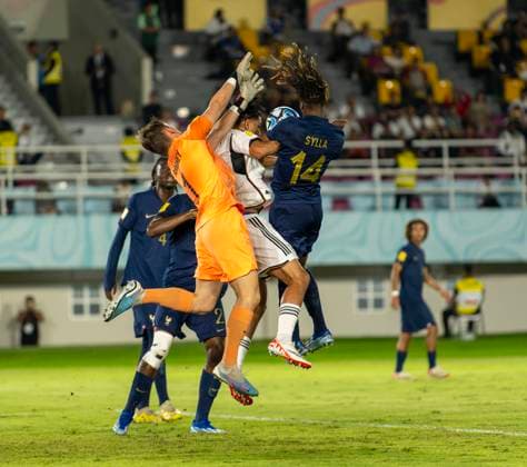 02.12.2023, Fussball U-17-Weltmeisterschaft 2023, Finale: Deutschland - Frankreich, im Manahan Stadium (Surakarta). mitte: Paris Brunner (Deutschland) gegen FodŽ Sylla (re, FRA) und Torwart Paul Argney (li, Frankreich).
