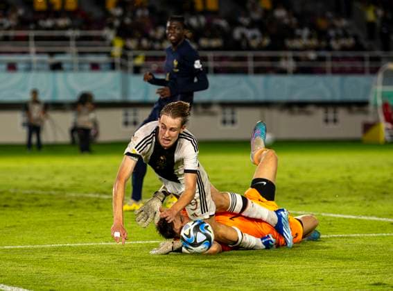 02.12.2023, Fussball U-17-Weltmeisterschaft 2023, Finale: Deutschland - Frankreich, im Manahan Stadium (Surakarta). Max Moerstedt (Deutschland) wird von Torwart Paul Argney (Frankreich) gefoult.
