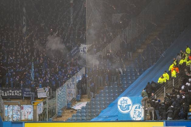 Rostock, Deutschland 10. Dezember 2023: 2. BL - 2023 2024 - FC Hansa Rostock vs. FC Schalke 04 Im Bild: Im Bild: Spielunterbrechung, Schalke fans haben einen Zaun geöffnet und auf Konfontration mit den Fans von Hansa Rostock. Dazwischen die Polizei und Ordner Beschuss von Pyro DFL regulations prohibit any use of photographs as image sequences and or quasi-video.