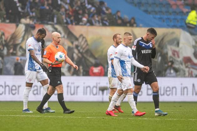 Rostock, Deutschland 10. Dezember 2023: 2. BL - 2023 2024 - FC Hansa Rostock vs. FC Schalke 04 Im Bild: 2.v.li. Schiedsrichter Nikolas Winter (Hagenbach) hat die Partie unterbrochen DFL regulations prohibit any use of photographs as image sequences and or quasi-video.