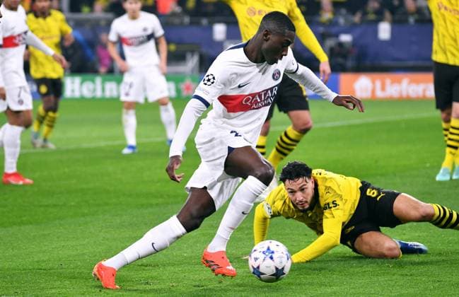 Fussball, Champions League, Deutschland, Herren, Saison 2023 2024, 6. Spieltag, Signal Iduna Park Dortmund: Bor. Dortmund - FC Paris Saint-Germain; Randal Kolo Muani (PSG), Ramy Bensebaini (BVB). Aktion UEFA REGULATIONS PROHIBIT ANY USE OF PHOTOGRAPHS AS IMAGE SEQUENCES AND OR QUASI-VIDEO