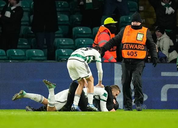 A Celtic fan on the pitch with Gustaf Lagerbielke of Celtic while Lagerbielke celebrates scoring to give Celtic a 2-1 lead. Celtic v Feyenoord, UEFA Champions League, Group E, Football, Celtic Park, Glasgow, UK - 13 Dec 2023 EDITORIAL USE ONLY No use with unauthorised audio, video, data, fixture lists, club league logos or live services. Online in-match use limited to 120 images, no video emulation. No use in betting, games or single club league player publications. Copyright: xStuartxWallace Shutterstockx 14254242bd
