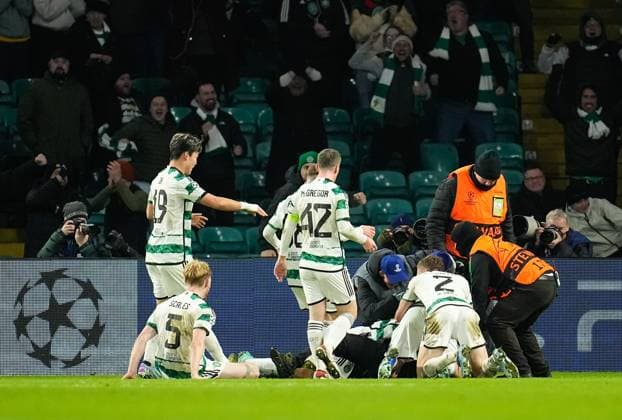 A Celtic fan on the pitch with Gustaf Lagerbielke of Celtic while Lagerbielke celebrates scoring to give Celtic a 2-1 lead. Celtic v Feyenoord, UEFA Champions League, Group E, Football, Celtic Park, Glasgow, UK - 13 Dec 2023 EDITORIAL USE ONLY No use with unauthorised audio, video, data, fixture lists, club league logos or live services. Online in-match use limited to 120 images, no video emulation. No use in betting, games or single club league player publications. Copyright: xStuartxWallace Shutterstockx 14254242bf