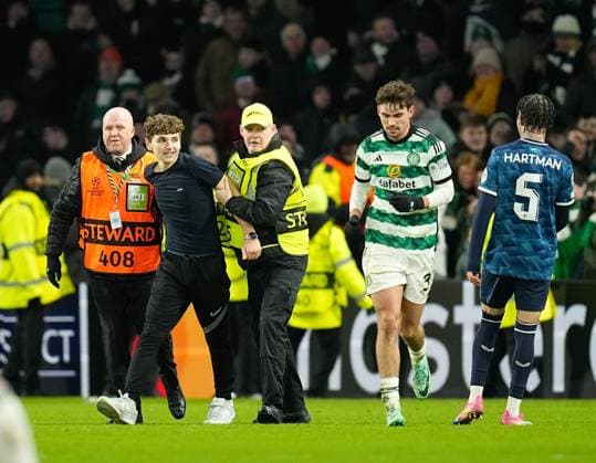 A Celtic fan on the pitch tries for a selfie picture with Matt O Riley of Celtic after Gustaf Lagerbielke of Celtic scored to give Celtic a 2-1 lead. Celtic v Feyenoord, UEFA Champions League, Group E, Football, Celtic Park, Glasgow, UK - 13 Dec 2023 EDITORIAL USE ONLY No use with unauthorised audio, video, data, fixture lists, club league logos or live services. Online in-match use limited to 120 images, no video emulation. No use in betting, games or single club league player publications. Copyright: xStuartxWallace Shutterstockx 14254242bx