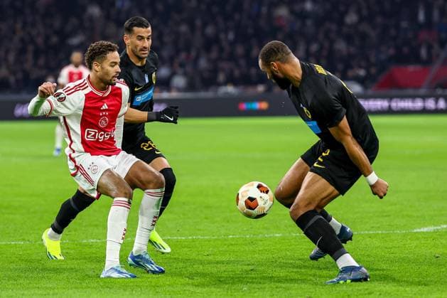 AMSTERDAM, 14-12-2023 , JohanCruyff Arena, Europa League Football season 2023 2024. Ajax player Devyne Rensch with AEK Athene player Harold Moukoudi (r) during the match Ajax - AEK Athens. Ajax - AEK Athens  x23520950x Copyright: