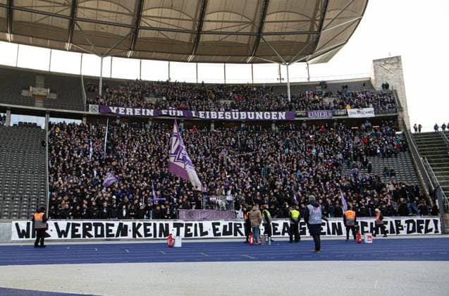 Fussball, Herren, Saison 2023 2024, 2. Bundesliga (17. Spieltag), Hertha BSC - VfL Osnabrück, Fans von Osnabrück mit Transparent im Gästeblock, Wir werden kein Teil eures Deals sein - scheiß DFL!, 16.12. 2023,