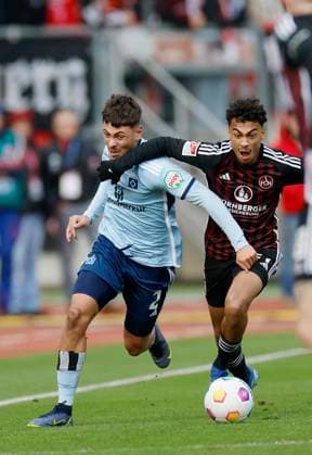 Bild: William Mikelbrencis (Hamburger SV, 2) und Nathaniel Brown (1.FC Nuernberg, 27). (l-r). 16.12.2023, Fussball, 2. Bundesliga, 1. FC Nürnberg - Hamburger SV, GER, Nuernberg, Max-Morlock-Stadion, DFL REGULATIONS PROHIBIT ANY USE OF PHOTOGRAPHS AS IMAGE SEQUENCES AND OR QUASI-VIDEO.