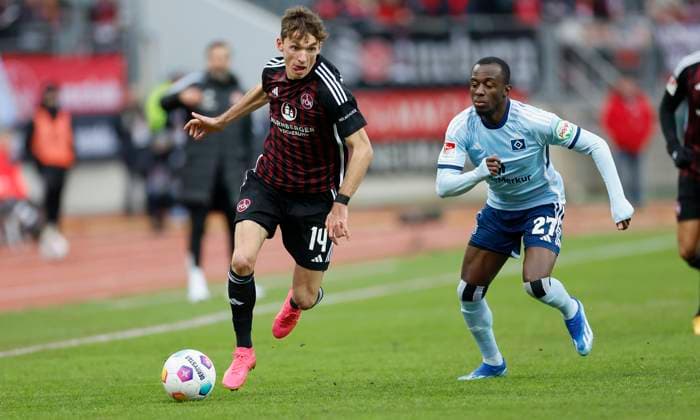 Bild: Benjamin Goller (1.FC Nuernberg, 14) und Jean-Luc Dompe (Hamburger SV, 27) (l-r). 16.12.2023, Fussball, 2. Bundesliga, 1. FC Nürnberg - Hamburger SV, GER, Nuernberg, Max-Morlock-Stadion, DFL REGULATIONS PROHIBIT ANY USE OF PHOTOGRAPHS AS IMAGE SEQUENCES AND OR QUASI-VIDEO.