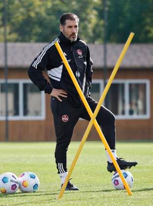 08.01.2024 - Fussball - 2. Fussball-Bundesliga - Saison 2023 2024 - 1. FC Nürnberg FCN Club - Trainingslager Winter Wintertrainingslager Marbella Spanien - Sportfoto Zink DaMa - xdaxmax - Cristian Fiel ( Trainer 1. FC Nürnberg FCN ) stellt nachdenklich Fuß auf den Ball und beobachtet Mannschaft Team bei Trainingseinheit Übung