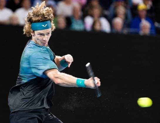 (240121) -- MELBOURNE, Jan. 21, 2024 -- Andrey Rublev of Russia hits a return during the men s singles fourth round match between Andrey Rublev of Russia and Alex De Minaur of Australia at Australian Open tennis tournament in Melbourne, Australia, Jan. 21, 2024. (Photo by Xinhua) (SP)AUSTRALIA-MELBOURNE-TENNIS-AUSTRALIAN OPEN HuxJingchen 