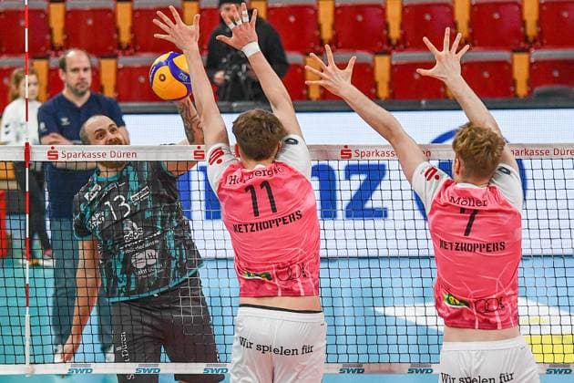 v.li.: Sebastian Gevert (Powervolleys Düren, 13) schmettert gegen den Block von Lovis Homberg (Netzhoppers KW, 11) und Carl Möller (Netzhoppers KW, 7), Aktion, Action, Spielszene