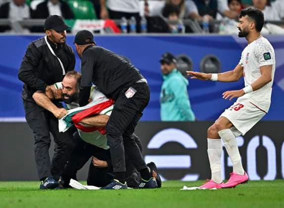 Fußball, Asienmeisterschaft, Iran - VAE Iran V United Arab Emirates: Group A- AFC Asian Cup A pitch invader is being apprehended by security while Ramin Rezaeian (R) of Iran reacts during the AFC Asian Cup 2023 match between Iran and the United Arab Emirates at Education City Stadium in Al Rayyan, Qatar, on January 23, 2023. DOHA Qatar  Copyright: xNoushadxThekkayilx originalFilename:varittyakkal-iranvuni240124_npt0t.jpg