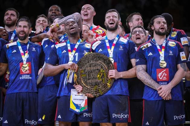 28.01.2024, EHF EURO 2024, Männer Europameisterschaft Handball, Lanxess Arena in Köln, Finale, Frankreich - Dänemark: Frankreich ist Europameister. Die französische Mannschaft feiert den Sieg gegen Dänemark. Siegerehrung auf dem Siegerpodest. Dylan Nahi (Frankreich) und Nedim Remili (Frankreich) halten während der Nationalhymne gemeinsam die Siegertrophäe. Die ganze Mannschaft singt die Hymne mit. Nordrhein-Westfalen Deutschland