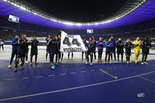 03.02.2024, xtgx, Fussball - 2.Bundesliga, Hertha BSC Berlin - Hamburger SV emspor, v.l. Hamburg Jubel ueber den Sieg, Jubel nach Spielende , sie halten ein Banner Spruchband in der Hand mit der Aufschrift Free 44 Vuskovic (DFL DFB REGULATIONS PROHIBIT ANY USE OF PHOTOGRAPHS as IMAGE SEQUENCES and or QUASI-VIDEO) Berlin