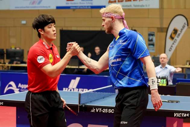 Dang Qiu (Borussia Duesseldorf) und Romain Ruiz (TTC Schwalbe Bergneustadt) geben sich die Hand, 1. Tischtennis Bundesliga der Herren, TTC Schwalbe Bergneustadt vs Borussia Düsseldorf, Burstenhalle, 04.02.2024, Bergneustadt, Deutschland.