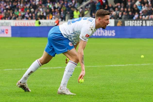 Janik Bachmann (Hansa Rostock) hebt einen von den Fans geworfenen Tennisball auf, 2. Bundesliga, VfL Osnabrueck vs Hansa Rostock, Bremer Bruecke, 11.02.2024, Osnabrueck, Deutschland.