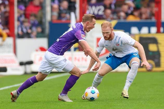 Thomas Goiginger (VfL Osnabrueck) und Christian Kinsombi (Hansa Rostock) kaempfen um den Ball, 2. Bundesliga, VfL Osnabrueck vs Hansa Rostock, Bremer Bruecke, 11.02.2024, Osnabrueck, Deutschland.