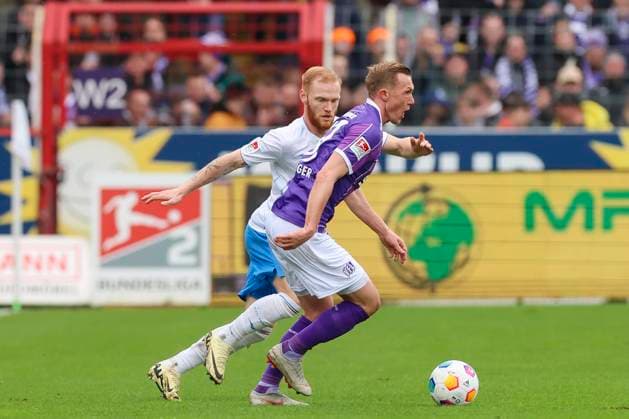 Thomas Goiginger (VfL Osnabrueck) und Christian Kinsombi (Hansa Rostock) kaempfen um den Ball, 2. Bundesliga, VfL Osnabrueck vs Hansa Rostock, Bremer Bruecke, 11.02.2024, Osnabrueck, Deutschland.