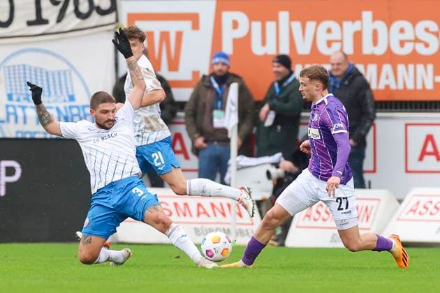 Konstantinos Stafylidis (Hansa Rostock) und Michael Cuisance (VfL Osnabrueck) kaempfen um den Ball, 2. Bundesliga, VfL Osnabrueck vs Hansa Rostock, Bremer Bruecke, 11.02.2024, Osnabrueck, Deutschland.
