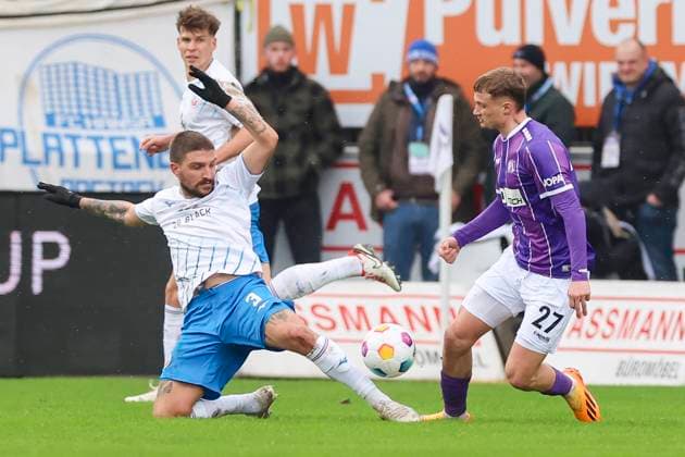 Konstantinos Stafylidis (Hansa Rostock) und Michael Cuisance (VfL Osnabrueck) kaempfen um den Ball, 2. Bundesliga, VfL Osnabrueck vs Hansa Rostock, Bremer Bruecke, 11.02.2024, Osnabrueck, Deutschland.
