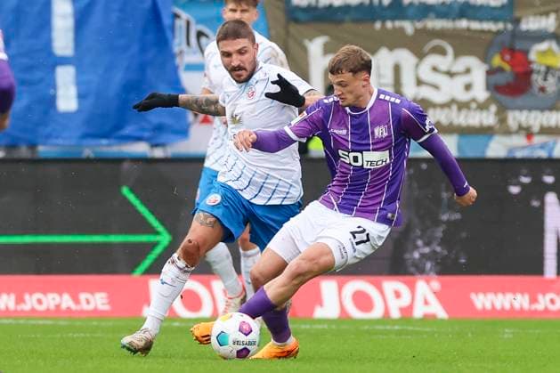 Konstantinos Stafylidis (Hansa Rostock) und Michael Cuisance (VfL Osnabrueck) kaempfen um den Ball, 2. Bundesliga, VfL Osnabrueck vs Hansa Rostock, Bremer Bruecke, 11.02.2024, Osnabrueck, Deutschland.