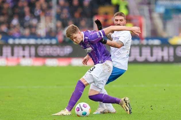 Lukas Kunze (VfL Osnabrueck) und Konstantinos Stafylidis (Hansa Rostock) kaempfen um den Ball, 2. Bundesliga, VfL Osnabrueck vs Hansa Rostock, Bremer Bruecke, 11.02.2024, Osnabrueck, Deutschland.