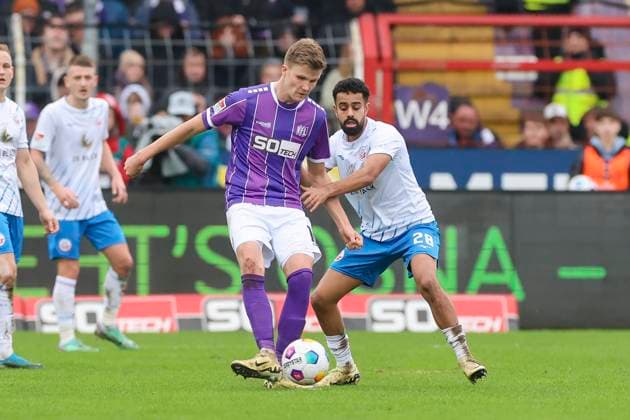Lukas Kunze (VfL Osnabrueck) und Sarpreet Singh (Hansa Rostock) kaempfen um den Ball, 2. Bundesliga, VfL Osnabrueck vs Hansa Rostock, Bremer Bruecke, 11.02.2024, Osnabrueck, Deutschland.