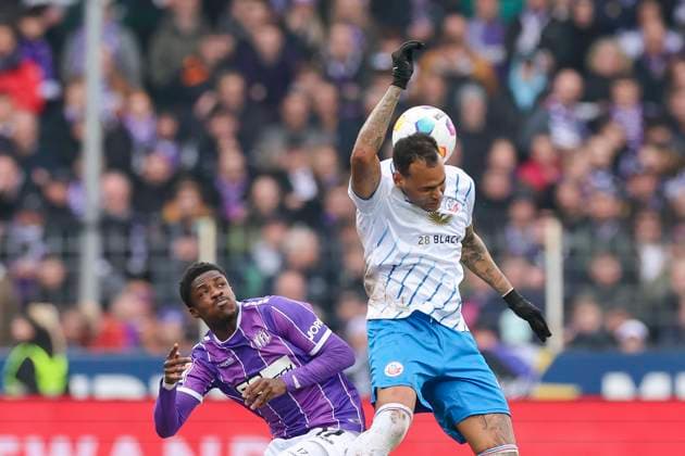 Christian Conteh (VfL Osnabrueck) und Junior Brumado (Hansa Rostock) kaempfen um den Ball, 2. Bundesliga, VfL Osnabrueck vs Hansa Rostock, Bremer Bruecke, 11.02.2024, Osnabrueck, Deutschland.