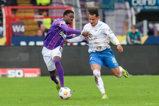 Christian Conteh (VfL Osnabrueck) und Juan-Jose Perea (Hansa Rostock) kaempfen um den Ball, 2. Bundesliga, VfL Osnabrueck vs Hansa Rostock, Bremer Bruecke, 11.02.2024, Osnabrueck, Deutschland.