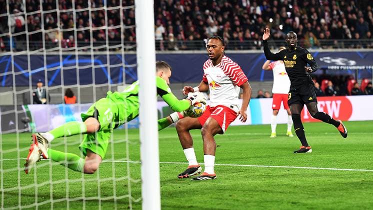 Fußball UEFA Champions League, Saison 2023 2024, Achtelfinale, Hinspiel, RB Leipzig vs. Real Madrid (13.02.2024) Andriy Lunin (Torwart Real Madrid, Rückennummer 13) (li.) pariert einen Ball vor Lois Openda (Mittelstuermer RB Leipzig, Rueckennummer 17, 17) beim Spiel RB Leipzig gegen Real Madrid (13.02.2024) Leipzig Sachsen Deutschland Red Bull Arena