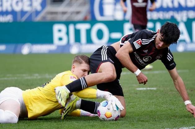 Bild: v. li. Torwart Julian Krahl (1.FC Kaiserslautern, 18) und Can Uzun (1.FC Nuernberg, 42). 18.02.2024, Fussball, 2. Bundesliga, 1. FC Nuernberg - 1. FC Kaiserslautern, GER, Nuernberg, Max-Morlock-Stadion DFL REGULATIONS PROHIBIT ANY USE OF PHOTOGRAPHS AS IMAGE SEQUENCES AND OR QUASI-VIDEO.