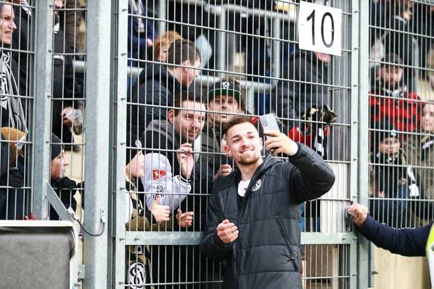 18.02.2024, xrhsx, Fussball 2.Bundesliga, SV Elversberg - VfL Osnabrück emspor, v.l. Trainer Luca Schnellbacher (SV Elversberg) am Zaun bei den Fans Selfi Handy Mobilfunkgerät (DFL DFB REGULATIONS PROHIBIT ANY USE OF PHOTOGRAPHS as IMAGE SEQUENCES and or QUASI-VIDEO) Elversberg