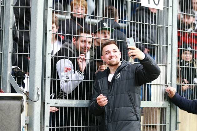 18.02.2024, xrhsx, Fussball 2.Bundesliga, SV Elversberg - VfL Osnabrück emspor, v.l. Trainer Luca Schnellbacher (SV Elversberg) am Zaun bei den Fans Selfi Handy Mobilfunkgerät (DFL DFB REGULATIONS PROHIBIT ANY USE OF PHOTOGRAPHS as IMAGE SEQUENCES and or QUASI-VIDEO) Elversberg