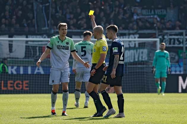 09.03.2024, xavx, Fussball 2.Bundesliga, SV Wehen Wiesbaden - Hannover 96 emspor, v.l. Referee Schiedsrichter Patrick Schwengers zeigt die Gelbe Karte fuer, shows yellow card to Fabian Kunze (Hannover 96) (DFL DFB REGULATIONS PROHIBIT ANY USE OF PHOTOGRAPHS as IMAGE SEQUENCES and or QUASI-VIDEO) Wiesbaden