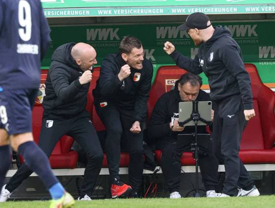 Schlussjubel an der Augsburger Trainerbank, vl.: Jacob Friis (Co.-Trainer FC Augsburg), Lars Knudsen (Co.-Trainer FC Augsburg), Remigius Elert (Videoanalyst FC Augsburg), Jonas Scheuermann (Co.-Trainer FC Augsburg); FC Augsburg vs. 1. FC Heidenheim, 25. Spieltag; DFL REGULATIONS PROHIBIT ANY USE OF PHOTOGRAPHS AS IMAGE SEQUENCES AND OR QUASI-VIDEO.