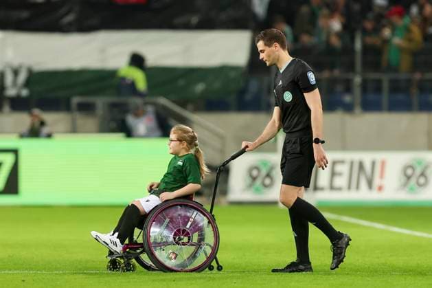 Sport Bilder des Tages Ein behindertes Maedchen im Rollstuhl wird von Schiedsrichter Dr. Max Burda auf den Platz gefahren, 2. Bundesliga, Hannover 96 vs 1. FC Kaiserslautern, HDI-Arena, 16.03.2024, Hannover, Deutschland.