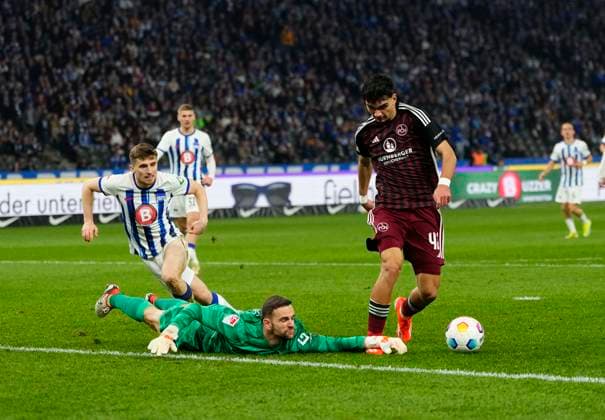 Germany, Berlin, 30.03.2024, Olympic Stadium, Hertha BSC vs 1.FC Nürnberg - 2. Bundesliga, Marius Gersbeck (Hertha Berlin) and Can Uzun (1.FC Nürnberg) battle for the ball Berlin Olympic Stadium Berlin Germany