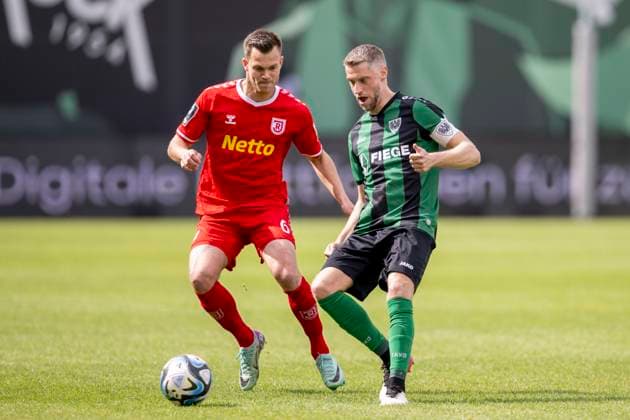 Fußball: 3. Liga, 32. Spieltag: Preußen Münster - Jahn Regensburg am 06.04.24 im Preußenstadion am Berg Fidel in Münster. Regensburgs Benedikt Saller (l.) und Münsters Marc Lorenz kämpfen um den Ball. WICHTIGER HINWEIS: Gemäß den Vorgaben der DFL Deutsche Fußball Liga bzw. des DFB Deutscher Fußball-Bund ist es untersagt, in dem Stadion und oder vom Spiel angefertigte Fotoaufnahmen in Form von Sequenzbildern und oder videoähnlichen Fotostrecken zu verwerten bzw. verwerten zu lassen.